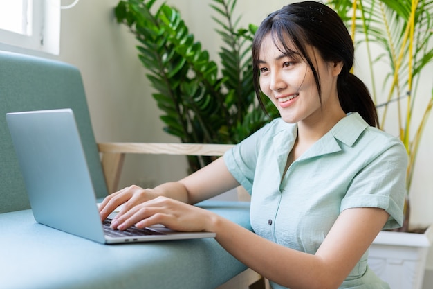 Jeune femme asiatique travaillant en ligne à domicile