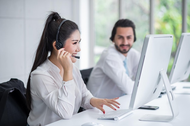 jeune femme asiatique travaillant à recevoir des appels porter des écouteurs consulter ou résoudre des problèmes