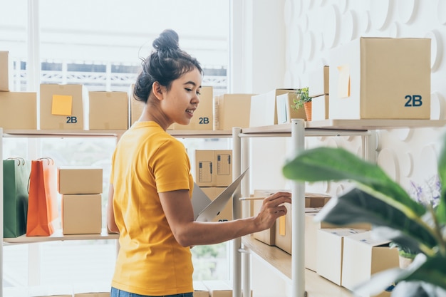 jeune, femme asiatique, vérification, marchandises, stockage, étagère, entrepôt