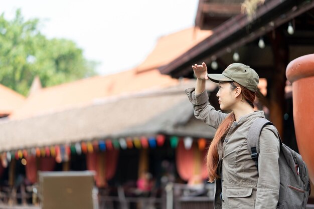 Jeune femme asiatique voyageur avec masque et sac à dos à la recherche et sourire à ayutthaya thaïlande Voyage vacances Relaxation Concept