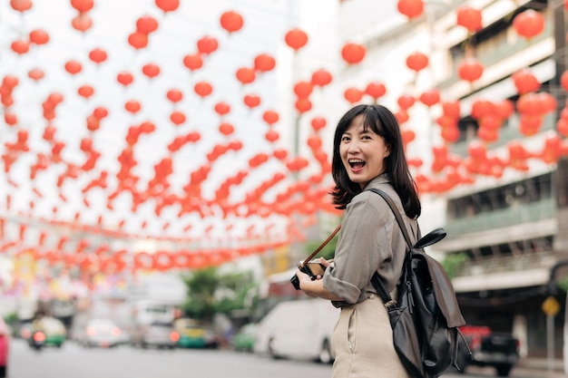 Jeune femme asiatique voyageur sac à dos appréciant le marché de l'alimentation de rue de la ville de Chine à Bangkok en Thaïlande Voyageur vérifiant les rues latérales