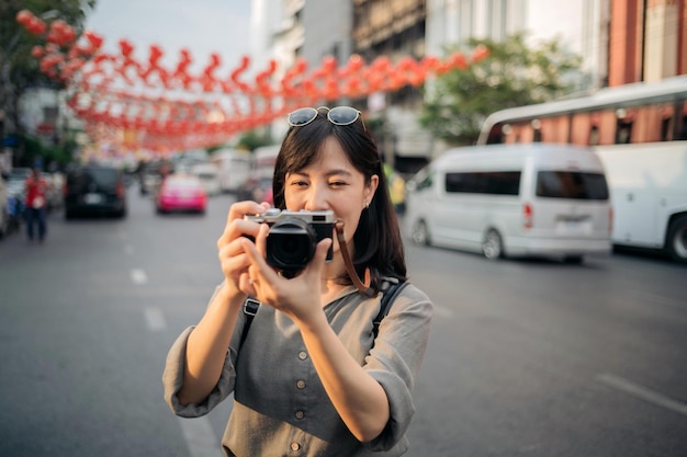 Jeune femme asiatique voyageur sac à dos appréciant le marché de l'alimentation de rue de la ville de Chine à Bangkok en Thaïlande Voyageur vérifiant les rues latérales