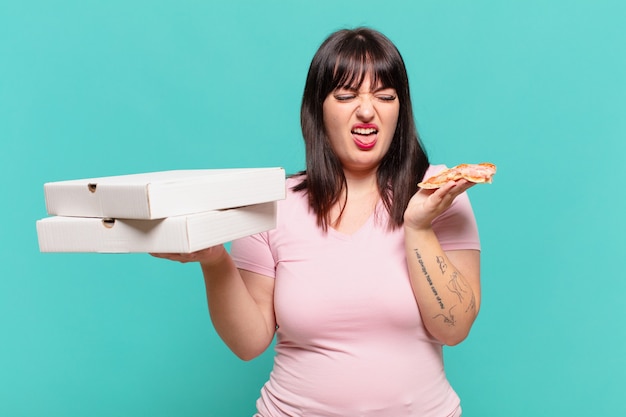 Jeune femme assez courbée expression triste et tenant une pizza