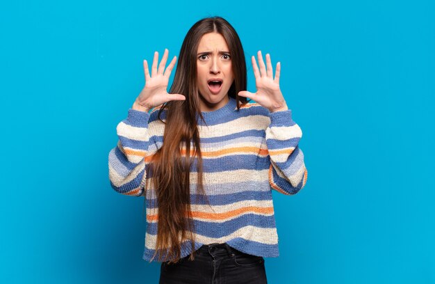 Jeune femme assez décontractée hurlant les mains en l'air, se sentant furieuse, frustrée, stressée et bouleversée