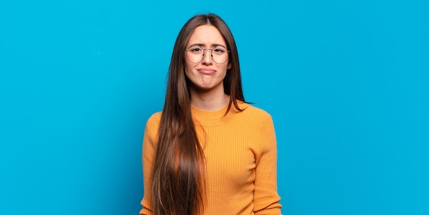 Jeune femme assez décontractée qui a l'air maladroite et drôle avec une expression stupide qui louche