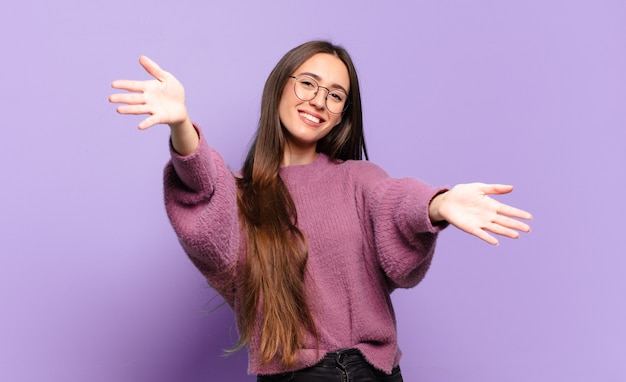 Jeune femme assez décontractée souriant joyeusement donnant un câlin de bienvenue chaleureux, amical, aimant, se sentir heureux et adorable