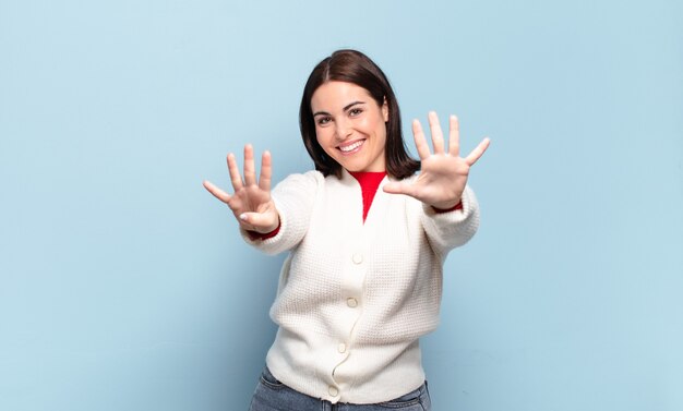 Jeune femme assez décontractée souriant et à la sympathique, montrant le numéro neuf ou neuvième avec la main en avant, compte à rebours