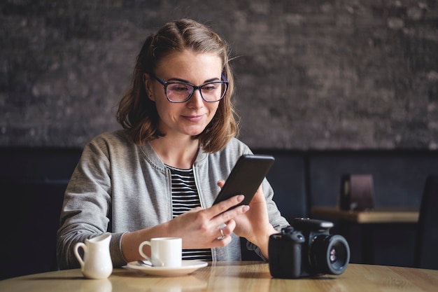 Jeune, femme, assis, cafétéria, utilisation, mobile