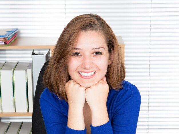 Jeune femme assise au bureau et travaillant