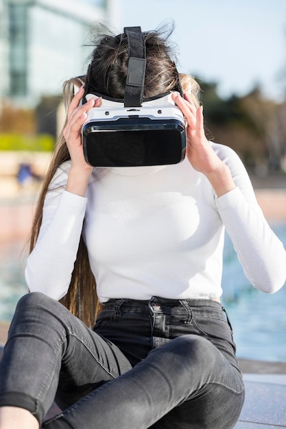 Jeune femme assise au parc et porte un ensemble VR Photo de haute qualité