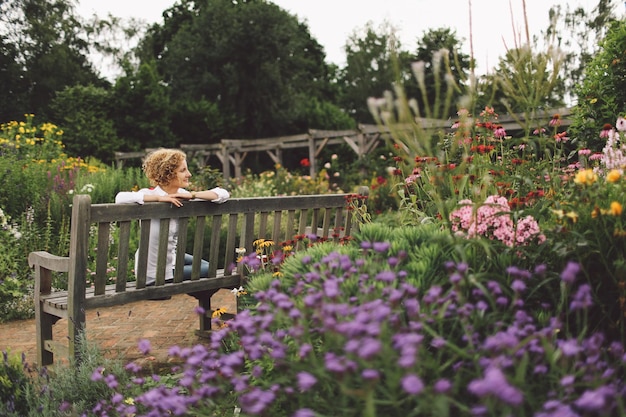 Une jeune femme assise sur un banc dans un parc.