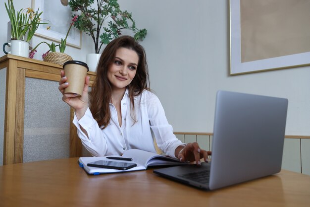 Jeune femme assise à un bureau et travaillant à la maison