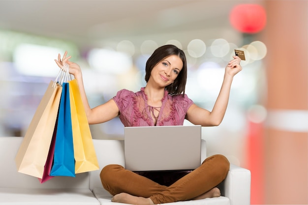 Jeune Femme Assise Sur Le Canapé Achats En Ligne Avec Des Sacs à Provisions.