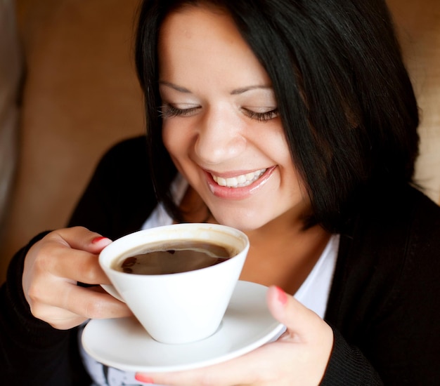 Jeune femme assise dans un café en buvant un café