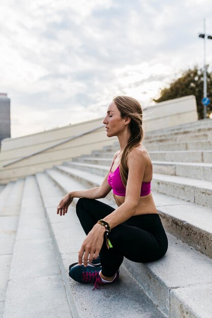 Jeune femme assise sur les escaliers après la formation