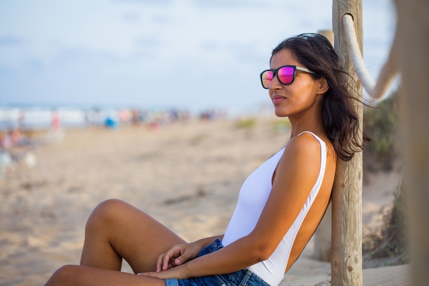 Jeune femme assise à la plage