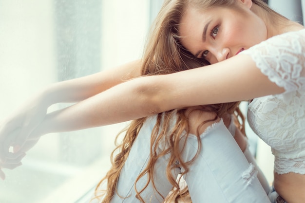 Jeune femme assise près de la fenêtre