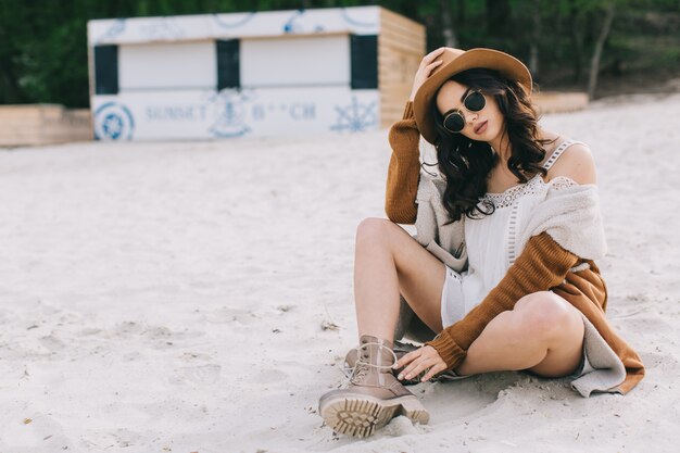 Jeune femme assise sur le sable