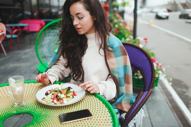Jeune femme assise seule dans un café ou un restaurant