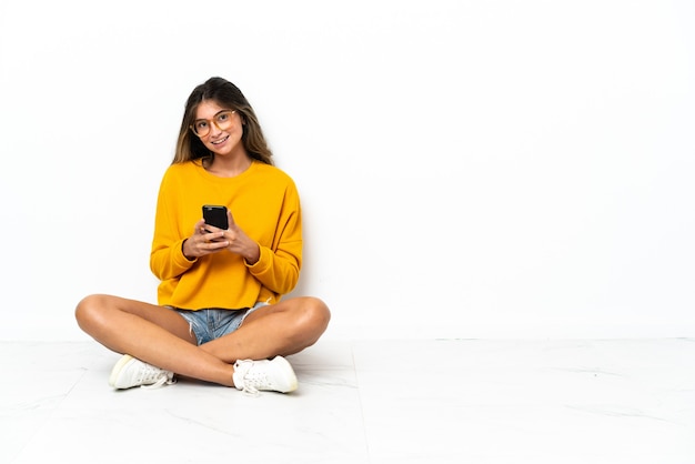 Jeune femme assise sur le sol isolé