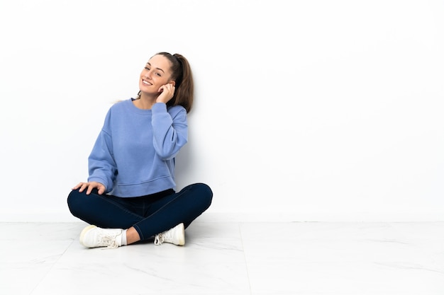 Jeune femme assise sur le sol en riant