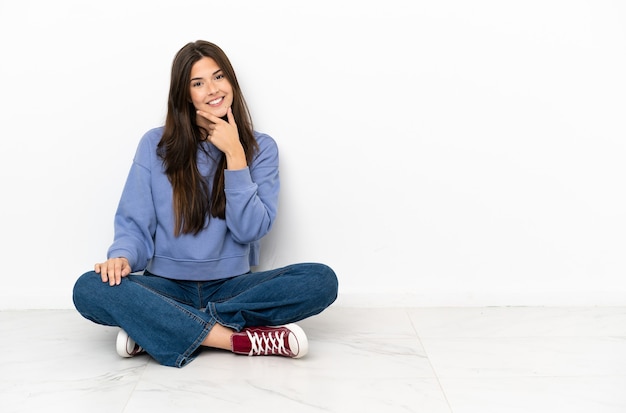 Jeune femme assise sur le sol souriant