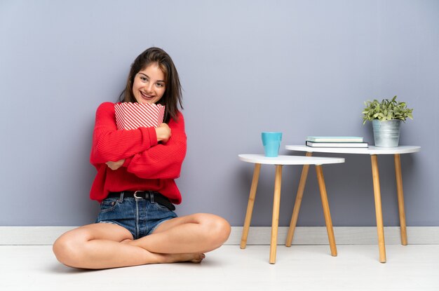 Jeune Femme Assise Sur Le Sol Et Tenant Des Pop-corn