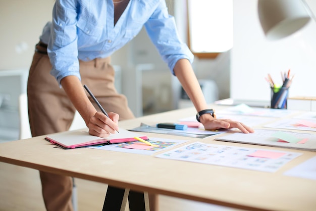 Jeune femme assise à la table de bureau