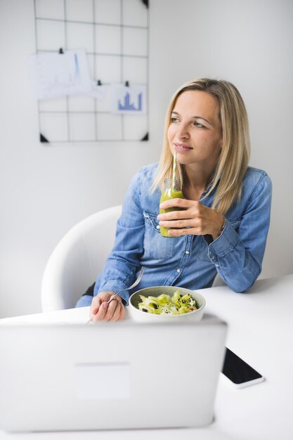 Une jeune femme assise sur une table.