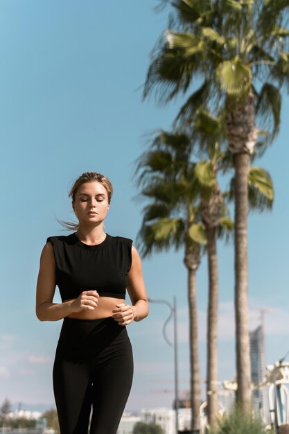 Une jeune femme athlétique court pendant son entraînement de jogging d'été