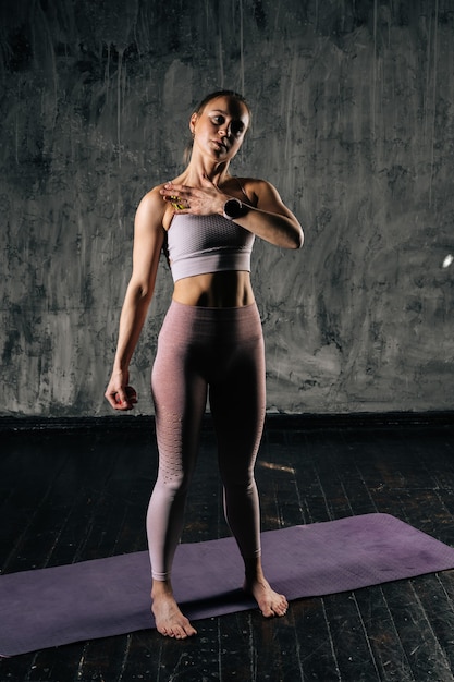 Jeune femme athlétique musclée avec un beau corps parfait portant des vêtements de sport à l'aide d'une balle de massage