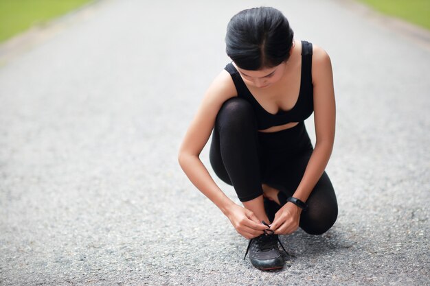 Jeune femme attachant des chaussures