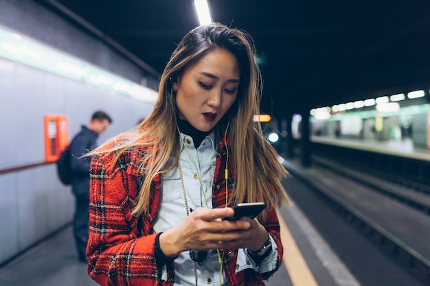 Photo jeune femme attendant le métro dans la station