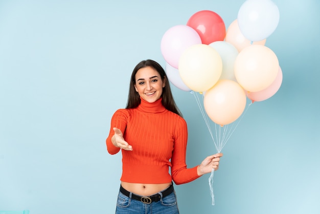 Jeune femme attraper de nombreux ballons