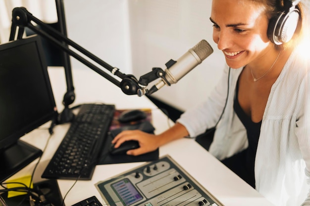 Photo une jeune femme attrayante portant des écouteurs et parlant dans une émission de radio en ligne.