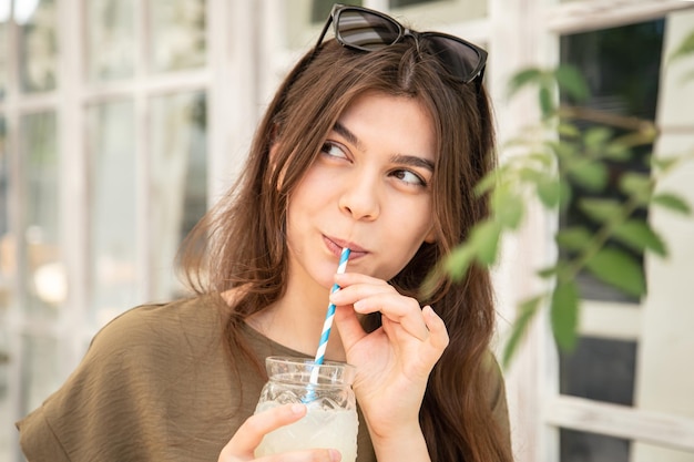 Une jeune femme attrayante avec un verre de limonade par une chaude journée d'été