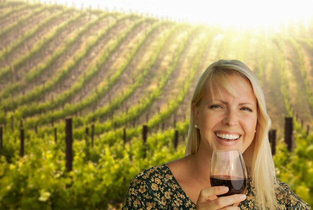 Photo une jeune femme attrayante avec un verre de vin dans une vigne