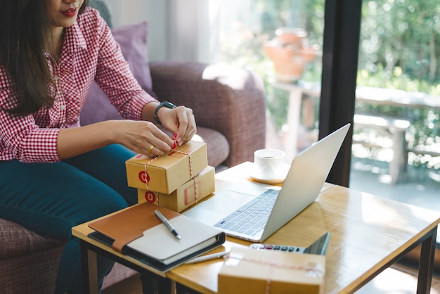 Jeune femme au bureau avec des paquets