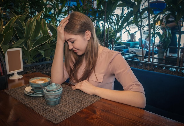 Une jeune femme au café.