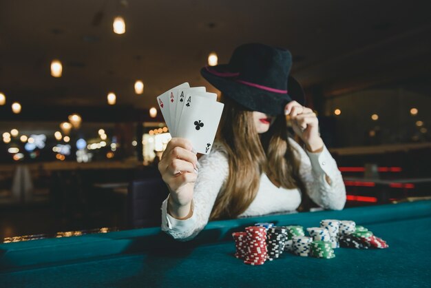 Jeune femme au casino avec quatre as