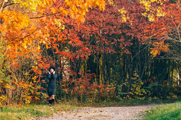 Jeune femme au chapeau avec une belle silhouette profitant de la nature du parc d'automne pendant la journée Concept des saisons