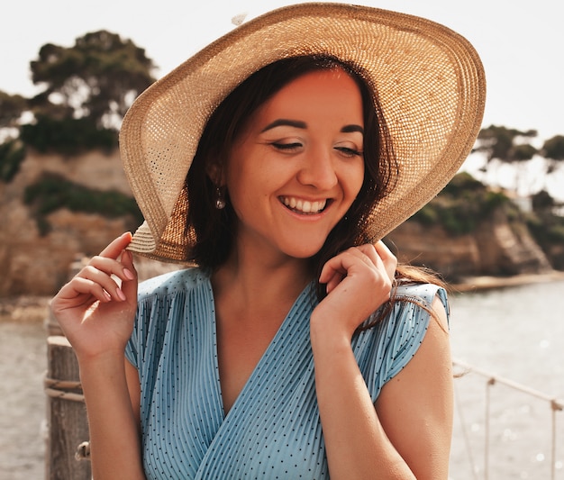 Jeune femme au chapeau d'été posant sur le pont