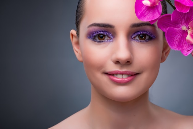 Jeune femme au concept de beauté avec fleur d&#39;orchidée