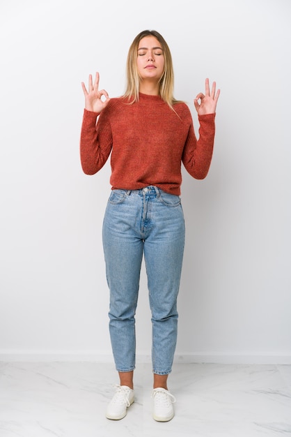 Jeune femme au corps entier se détend après une dure journée de travail, elle pratique le yoga.