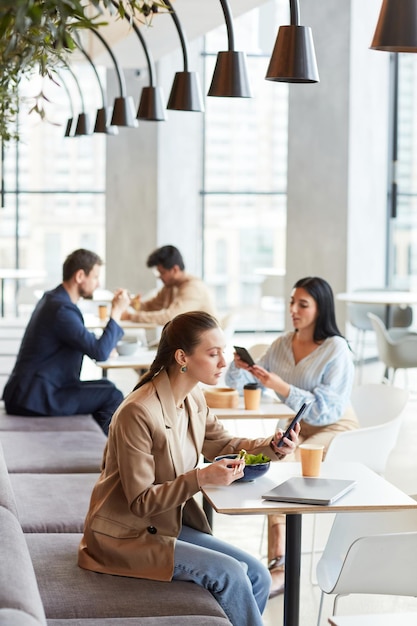 Jeune femme au déjeuner dans l'aire de restauration