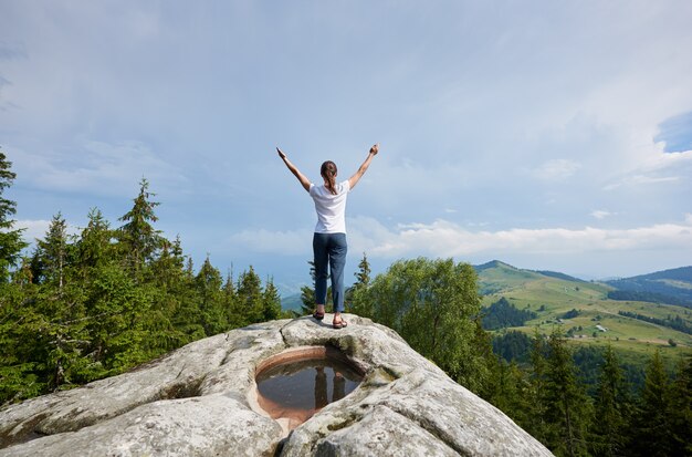 Jeune femme au repos sur une grosse pierre dans la journée d'été dans les Carpates