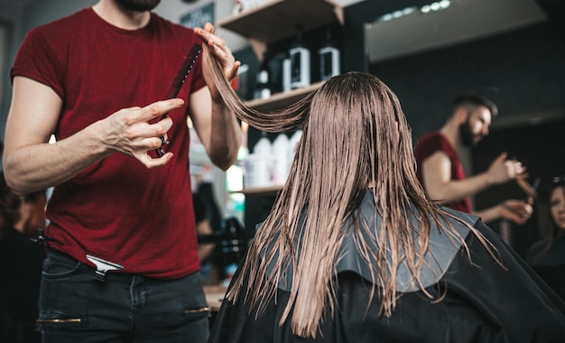 Jeune femme au salon de coiffure se débarrasser des pointes fourchues. La Coupe de cheveux.