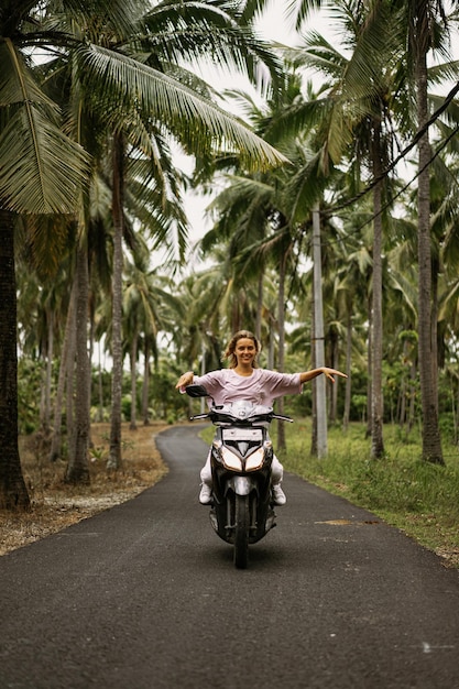 jeune femme au volant d'un cyclomoteur vie tropicale