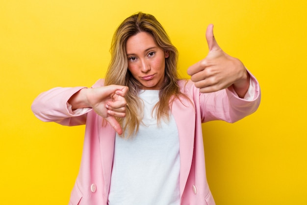 Jeune femme australienne isolée montrant les pouces vers le haut et les pouces vers le bas, difficile de choisir le concept