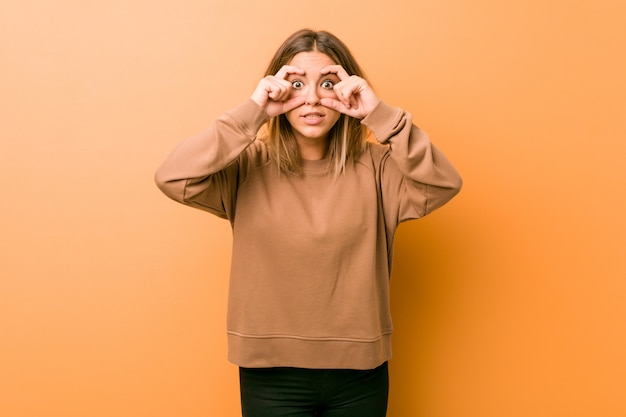 Jeune femme authentique de vrais gens charismatiques contre un mur en gardant les yeux ouverts pour trouver une opportunité de réussite.